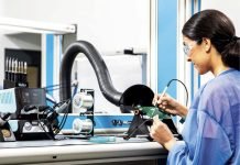 RS lance une station de soudage intelligente tout-en-un Une femme utilise un ordinateur dans un laboratoire tout en testant la nouvelle station de soudage intelligente tout-en-un de RS.