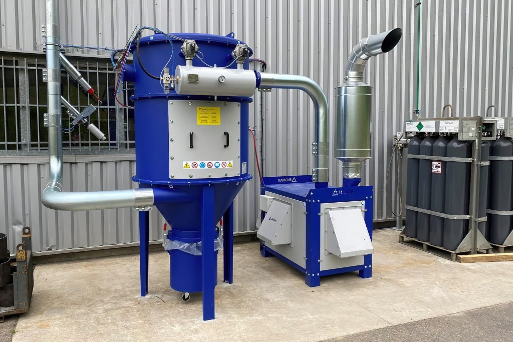 Une machine française se trouve à l'extérieur d'un bâtiment, conçu de manière innovante par Julien Cheere.