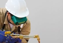 Un homme portant un casque travaille sur un tuyau.