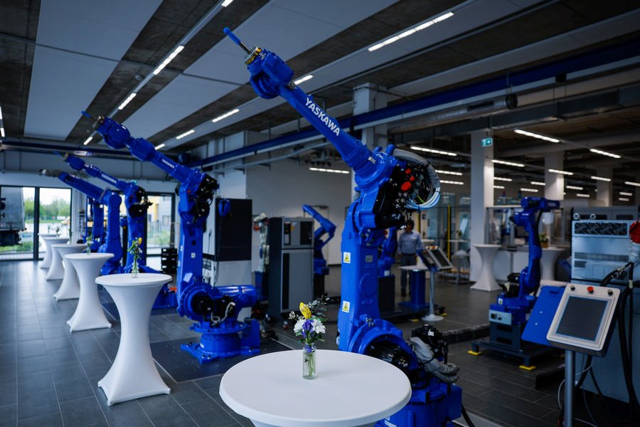 Yaskawa inaugure son nouveau siège européen plein de robots bleus et de tables.