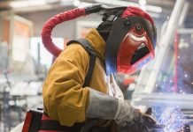 Un soudeur effectue des travaux de soudage dans une usine, exposé à des fumées et à des champs magnétiques.