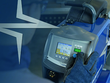 Un homme tient une machine à souder devant un écran bleu, garantissant une facilité d'utilisation pour une satisfaction maximale des soudeurs.