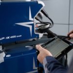 Un homme utilise une tablette pour assurer la satisfaction des soudeurs grâce à la facilité d'utilisation offerte par une machine.