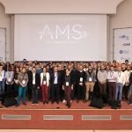 Un groupe de personnes debout devant un écran.