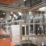Une vitrine en verre avec de nombreux objets dessus, avec des décorations imprimées en 3D.