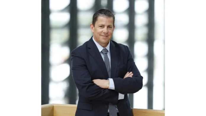 Un homme en costume-cravate pose pour une photo au salon Sébastien Gillet.