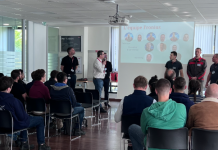 Visite immersive chez Fronius pour les étudiants EAPS et ESSA de l’Institut de Soudure Un groupe de personnes est assis dans une salle de conférence de l'Institut de Soudure, face à un écran affichant une diapositive intitulée « Promesses des collègues ». Plusieurs individus se tiennent devant, parlant ou faisant une présentation. La salle dispose de grandes fenêtres laissant entrer la lumière naturelle, créant une atmosphère invitante pour cette visite immersive.