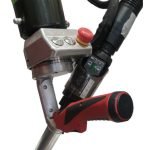 Gros plan d'un outil de soudage plastique portatif avec une poignée rouge et plusieurs boutons de commande. L'appareil semble avoir une buse pour chauffer et appliquer des matériaux, ainsi qu'un composant vert et noir fixé en haut.