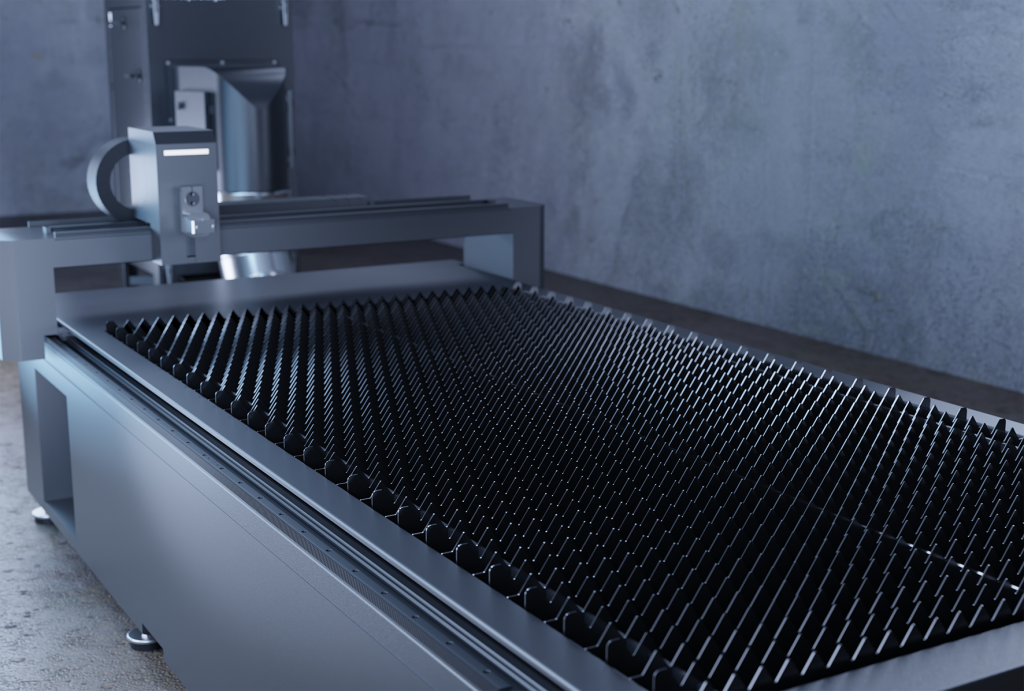 Machine industrielle avec une grande surface plane recouverte de pointes régulièrement espacées, probablement utilisées pour des solutions de découpe. L'équipement est placé contre un mur de béton gris uni, suggérant un décor d'usine ou d'atelier. La scène est brillamment éclairée, mettant en valeur les textures métalliques.