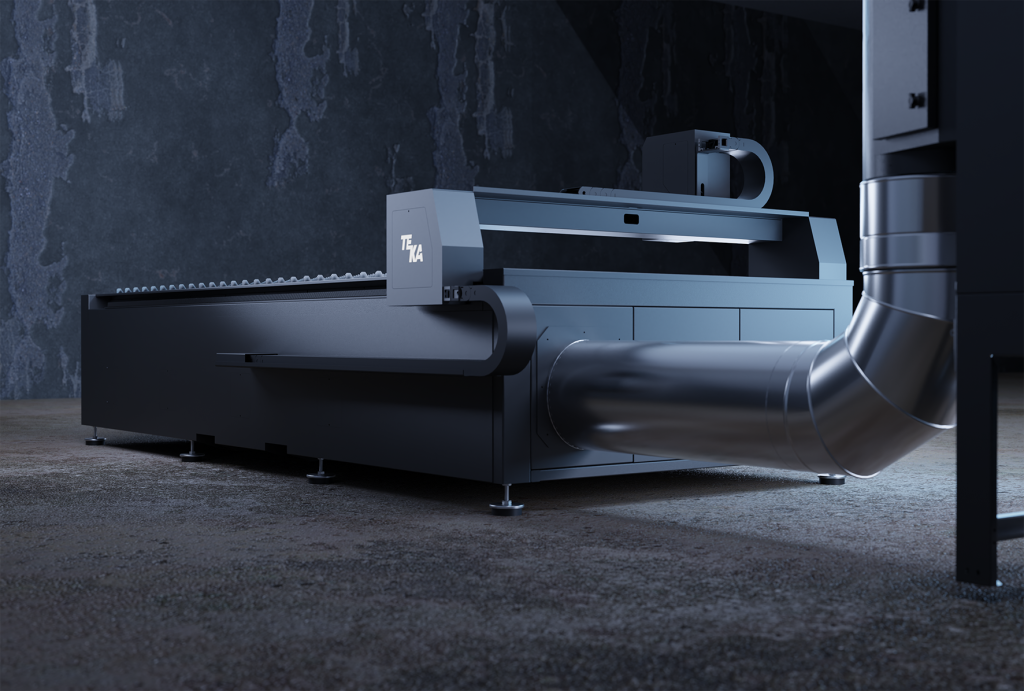 Une grande machine industrielle à l'aspect métallique et épuré se dresse dans une pièce faiblement éclairée. Avec son tuyau d'aération proéminent et ses solutions de découpe de pointe, la machine est encadrée par des murs texturés et sombres.