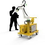 Un bras robotisé jaune est monté sur une base mobile à roulettes, positionné devant une silhouette tenant un câble. Cette configuration innovante évoque un environnement industriel ou de fabrication, mettant en valeur les avancées de la robotique et de la technologie du soudage.