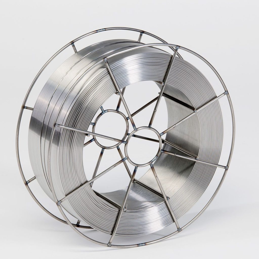 Une grande bobine de fil métallique est enroulée étroitement dans un cadre métallique circulaire. Le fil lisse et brillant suggère qu'il pourrait être utilisé à des fins de soudage, même sur les chantiers navals. Le fond blanc met en valeur la texture métallique.