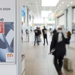 Affiche annonçant les événements Wire and Tube Düsseldorf 2026, avec les dates du 13 au 17 avril 2026, présentée dans un hall d'exposition moderne et lumineux. Des personnes marchent et se tiennent debout en arrière-plan, reflétant l'esprit d'innovation et les concepts automobiles de Brouillon.