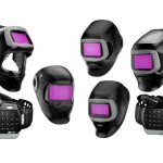 Six casques de soudage Speedglas noirs avec des visières teintées en violet sont disposés en deux rangées. Certains casques, véritables pionniers de la protection de soudage, sont équipés de respirateurs et de tuyaux. L'arrière-plan est blanc.