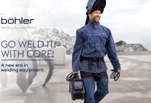 Un homme portant un équipement de protection pour le soudage transporte un équipement de soudage portable CORE à l'extérieur, près d'un équipement industriel et de piles de roches. Le texte se lit comme suit : "Böhler, soudage par voestalpine. Allez souder ! Avec Core. Une nouvelle ère dans l'équipement de soudage pour les professionnels.