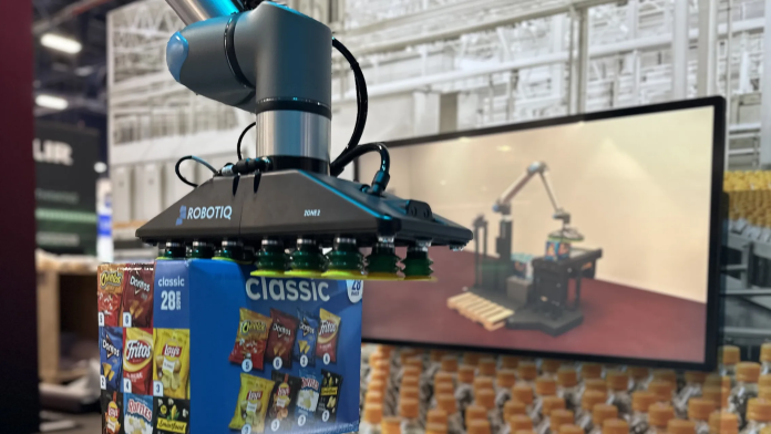Un bras robotisé doté d'une pince aspirante tient une boîte de chips assorties ; un écran à l'arrière-plan affiche un graphique d'un bras robotisé similaire dans un entrepôt.