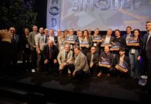 Simodec 2026 : salon international du décolletage et de l’usinage de précision Un grand groupe de personnes, certaines debout et d'autres agenouillées, posent ensemble sur une estrade en tenant des prix. Une bannière en arrière-plan indique "SIMODEC". La plupart des personnes sont souriantes et plusieurs d'entre elles portent un badge de la conférence.