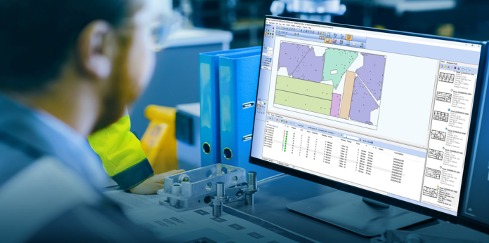 Dans un atelier ou un bureau, une personne est assise à un bureau et regarde un écran d'ordinateur affichant un logiciel de CAO ou d'ingénierie avec des diagrammes, des tableaux de données et des spécifications de pièces.