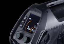 Vue rapprochée d'une machine à souder noire avec deux boutons verts, un écran numérique indiquant les réglages, des boutons de réglage, et divers connecteurs et commandes sur le panneau avant.