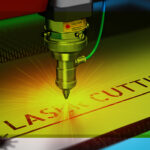 Gros plan d'une machine de découpe au laser en fonctionnement, émettant une lumière jaune vive tandis qu'elle découpe les mots "LASER CUTTING" dans une feuille de métal. Des étiquettes de sécurité et des détails techniques sont visibles sur la machine.