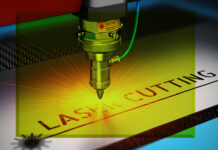 Gros plan d'une machine de découpe au laser en fonctionnement, émettant une lumière jaune vive tandis qu'elle découpe les mots "LASER CUTTING" dans une feuille de métal. Des étiquettes de sécurité et des détails techniques sont visibles sur la machine.