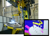 Un bras robotisé soude une pièce métallique dans un environnement industriel, tandis qu'un ordinateur portable situé à proximité affiche un modèle 3D de la pièce en cours d'usinage.