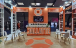 Stand d'exposition aux couleurs orange et blanc, présentant la marque « Jallatte ». Le stand comprend des étagères avec des produits, une grande enseigne, des tables rondes avec des chaises, ainsi qu'un sol en bois orné d'un logo orange.