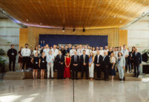 Golden Tech 2026 à Bercy : lauréats et cap sur 2027 Un grand groupe de personnes en tenue professionnelle et habillée pose pour une photo de groupe dans un espace intérieur moderne et bien éclairé, avec un fond bleu derrière elles. Certaines personnes portent des badges nominatifs.